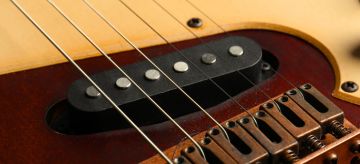 The relationship between the magnetic pickup and electric guitar string material